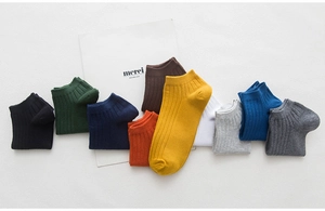 Macro shot of 10 solid color cotton ankle socks for men in a neat lifestyle display