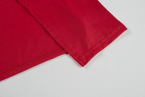 Detail shot of the double-needle stitching and high-quality hem on a red dress fabric