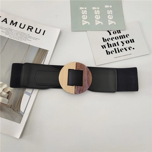 Macro detail of elastic black waist belt with gold and marble resin round buckle