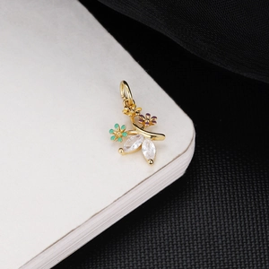 Macro shot of 18K gold floral pendant with green purple crystals and zircon leaves