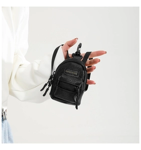 Close-up of mini black faux leather leopard-style bag charm with zipper details