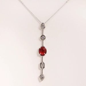 Detailed close-up of 18K gold plated necklace with red oval gemstone and clear accents