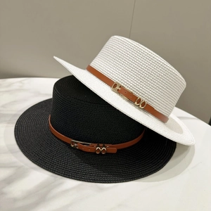 Detail of woven straw boaters with brown leather bands and gold hardware accents