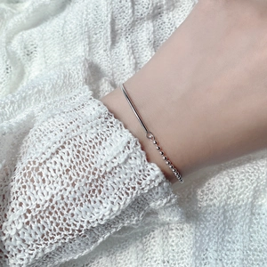Minimalist S925 sterling silver bracelet with tube and bead design on a model wrist