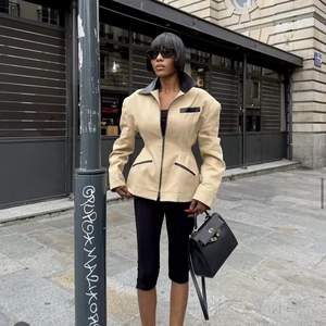 Fashionable waist-cinching jacket with shoulder pads and leather patchwork in khaki and black