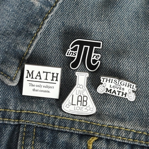Science and math enamel pin set with π, Lab, and Math slogans on blue denim jacket