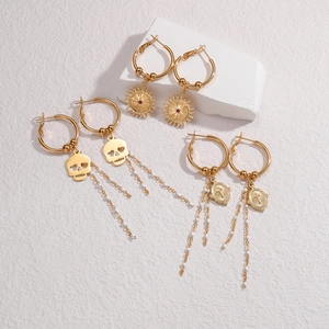 Golden stainless steel earring set with skull sun tassels and white beads on stone base