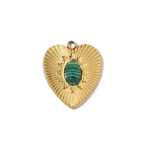 Macro shot of a vintage heart pendant with gold texture and green malachite gemstone
