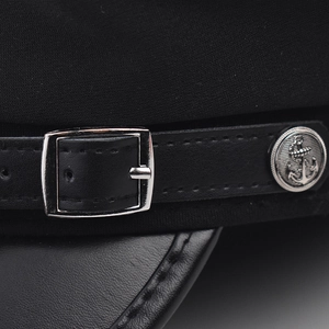 Détails macro d'une casquette militaire avec visière en cuir et bouton ancre argenté