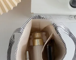 Detail view of large striped tote bag interior with compartments for skincare items
