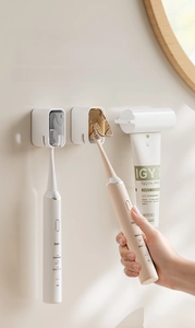 Detail view of wall-mounted toothbrush holder with dustproof cover and toothpaste dispenser