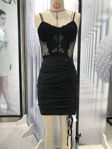 Detail of black satin bodycon dress with lace trim and ruched drawstring texture