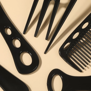 6-piece black hair styling comb set with ergonomic handles on a beige background