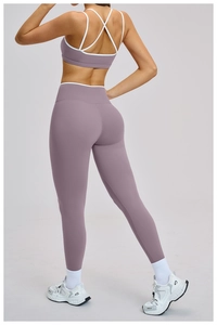 Dettaglio posteriore di un set yoga lilla con spalline incrociate e profili a contrasto