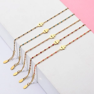 Detailed shot of five golden Hamsa Hand bracelets with colorful beads on a white display