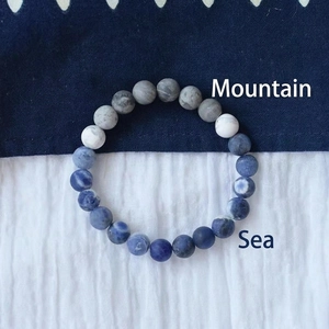 Bracelet en perles de pierre naturelle veinées gris au design zen et cordon élastique