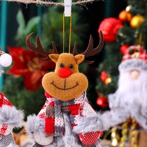 Detail of plush reindeer ornament with red nose and plaid scarf on Christmas tree