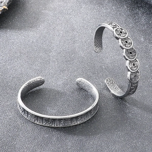 Close-up of retro titanium steel bracelet with Chinese Five Emperors coins and blessings