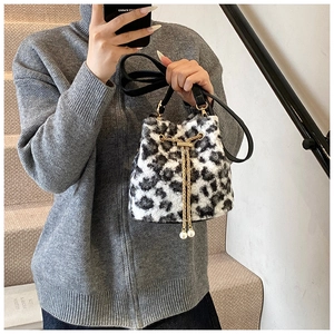 Detail of plush leopard print bucket bag featuring metal chain drawstring and pearl accents