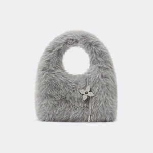 Détail du petit sac à main en fausse fourrure grise avec texture pelucheuse et fleur