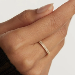 Close-up of double row diamond-encrusted gold ring on model finger showing fine texture