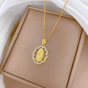 Macro shot of oval gold necklace with religious portrait and sparkling crystal border