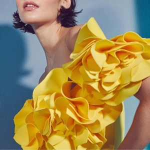 Detailed close-up of oversized 3D floral petals on a bright yellow one-piece swimsuit
