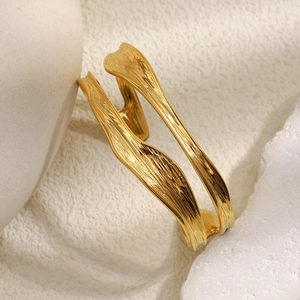 Detailed view of gold plated wavy texture bangle with polished lava style finish