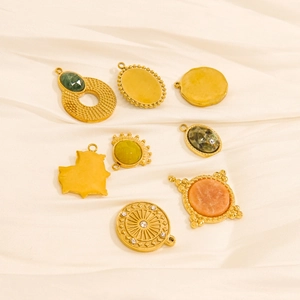 Eight assorted gold stainless steel natural stone pendants on beige silk background