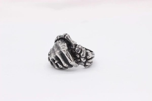 Detailed macro view of retro gothic handshake ring featuring skeletal hand motifs
