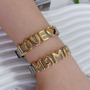 Detail of adjustable silver mesh bracelet featuring gold 'LOVE' and 'MAMA' charms