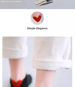 Close-up of white cotton ankle socks featuring red heart embroidery on the heel