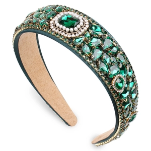 Baroque emerald crystal headband with pearls and gold alloy setting on white backdrop