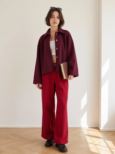 Detail of burgundy wool jacket, white crop top and red wide-leg trousers outfit set
