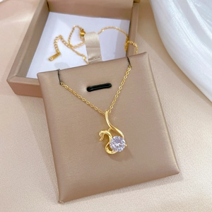 Close-up of golden swan necklace with sparkling crystal inlay in elegant jewelry box