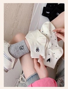 Close-up of cotton blend socks with embroidered cartoon dog and heart patterns
