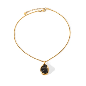 Detail of gold rope chain necklace featuring a smooth black organic shaped pendant