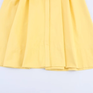 Detailed view of yellow shirt dress hemline with high-quality stitching and fabric texture
