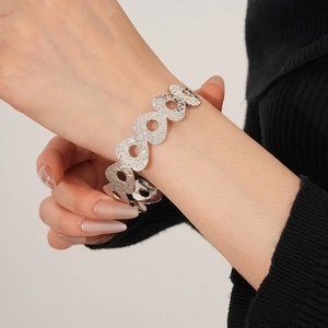 Detail of silver hollowed metal bangle with vintage hammered texture on wrist