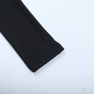 Detail of double-stitched cuffs on a black mesh patchwork knit dress with ruffle trim