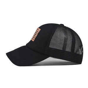 Detail of a black mesh trucker hat featuring a rectangular orange striped patch