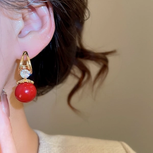 Détail de boucles d'oreilles carrées en zircon rouge sur modèle avec design doré rétro