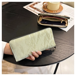 Detail of mint green long zipper wallet featuring multiple card slots and pleated texture