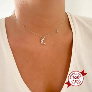 Close-up of S925 sterling silver moon and star necklace with zircon on model's neck