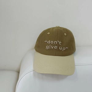 Detalle del bordado 'don't give up' en una gorra de béisbol bicolor en color caqui y beige