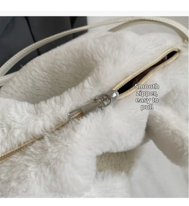 Detail of smooth silver zipper and soft white plush texture on the large capacity bag