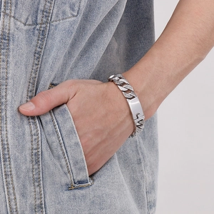 Détail du bracelet gourmette argenté pour homme serti de diamants sur fond en jean