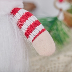 Gros plan sur les textures tricotées et la fausse fourrure d'un gnome de Noël festif