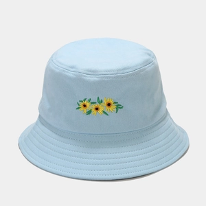 Détail de la broderie tournesol sur un chapeau bob en coton bleu clair avec coutures