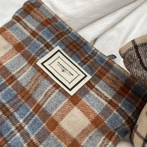 Macro view of vintage plaid wool fabric and woven label on a portable cosmetic storage bag